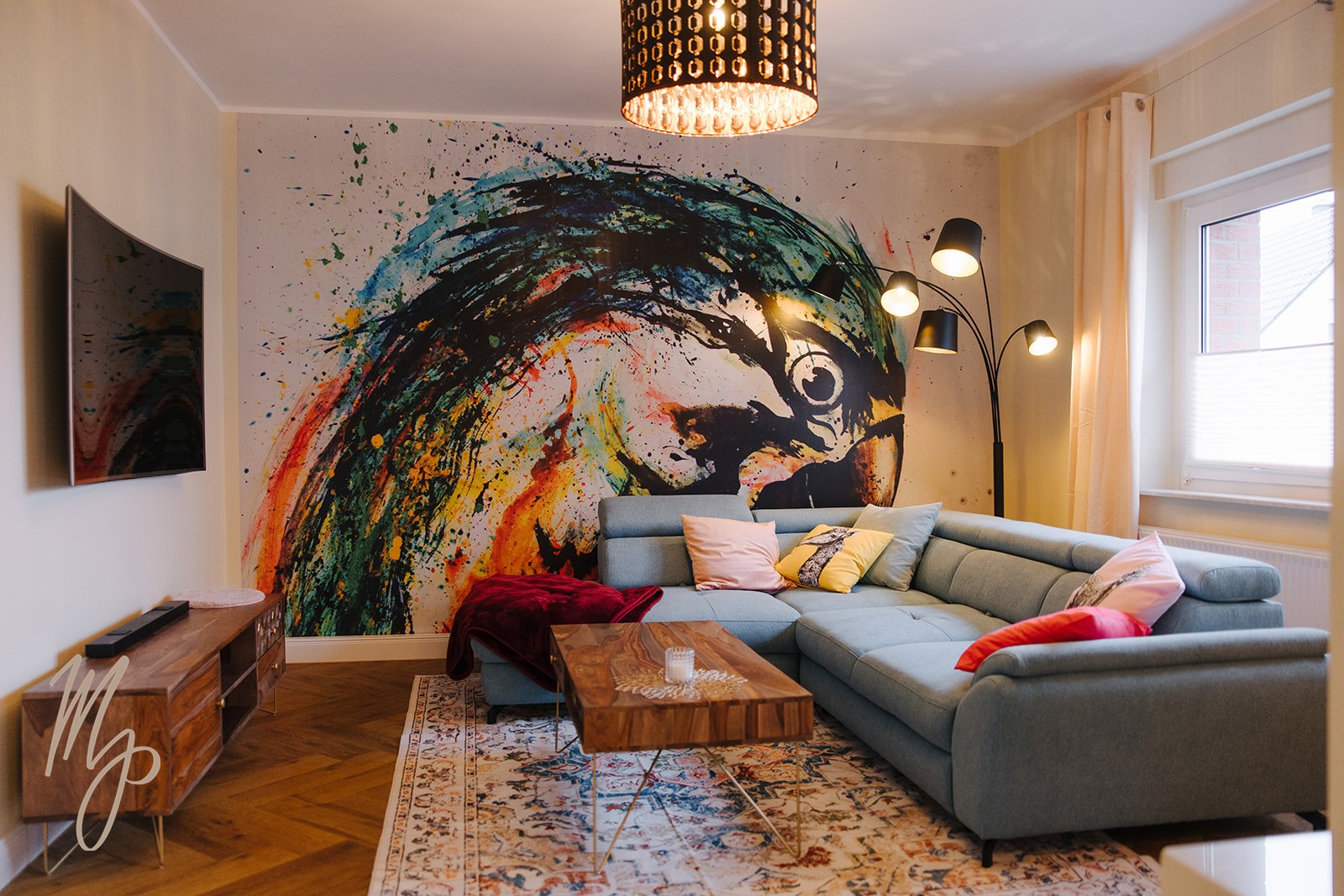 Wohnzimmer mit Eckcouch und großem Papagei-Wandbild